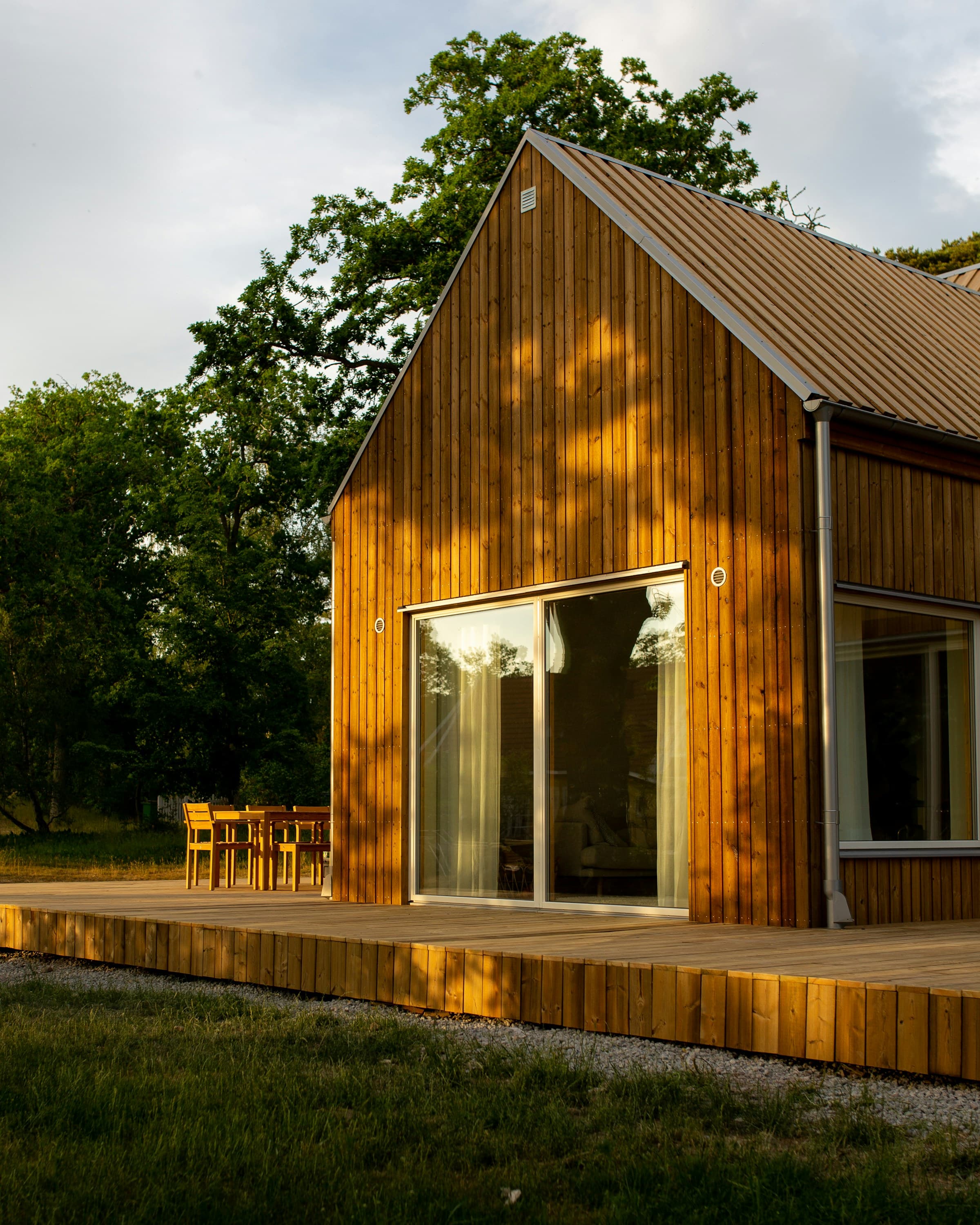 Trekledd hus med terrasse i kveldslys